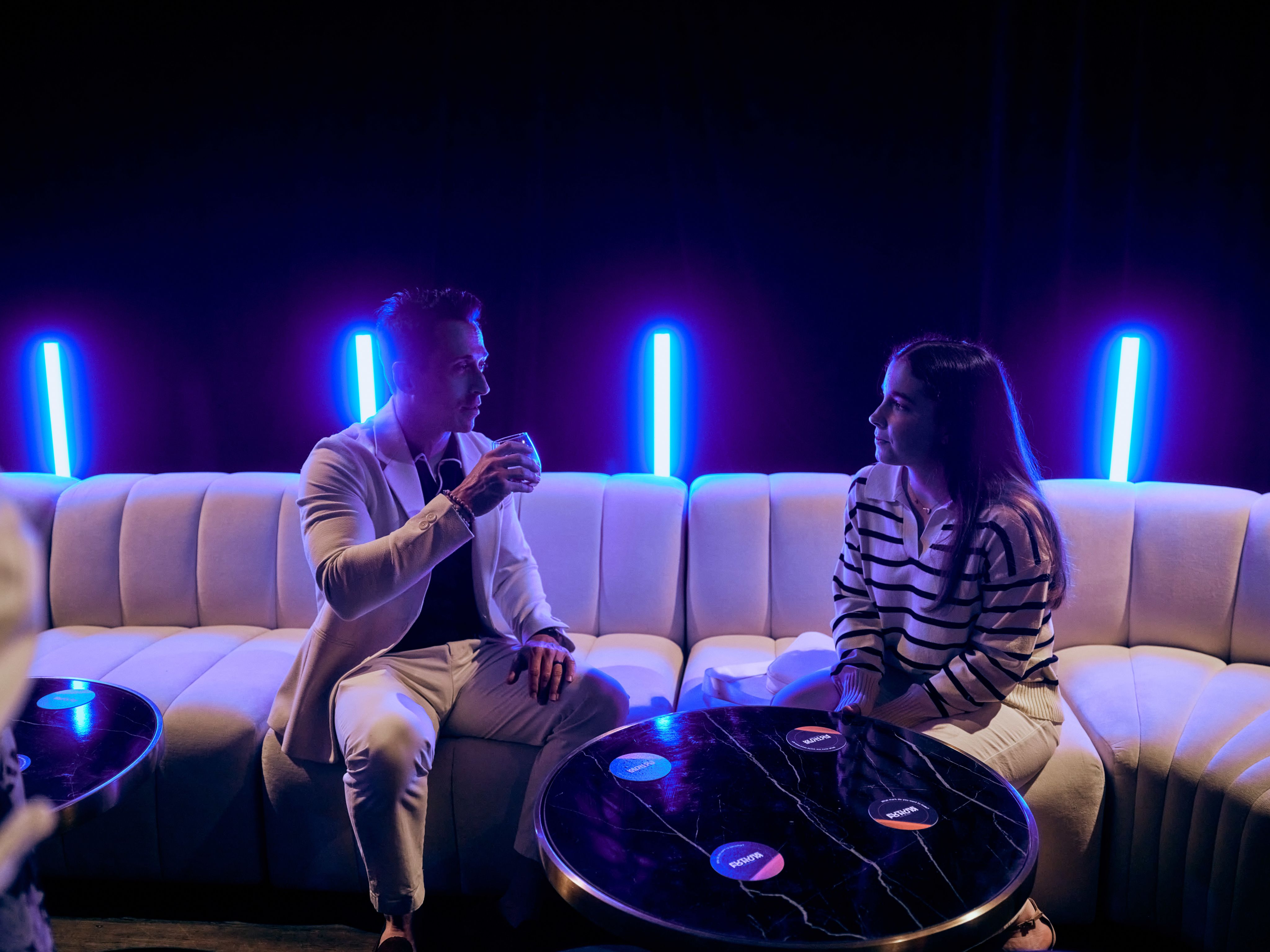 Two people are talking on a couch. 