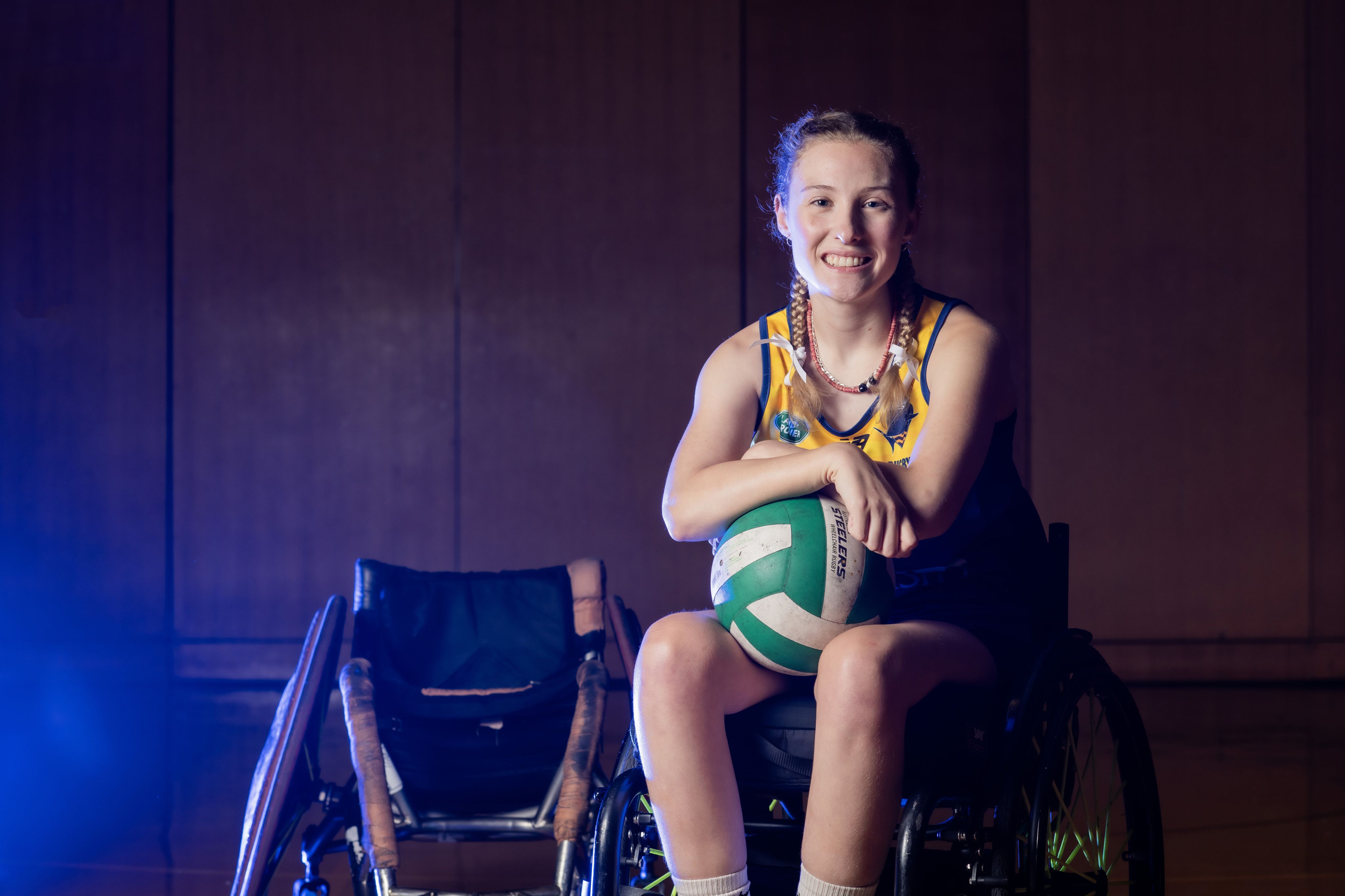 A woman in a wheelchair with a ball on her lap
