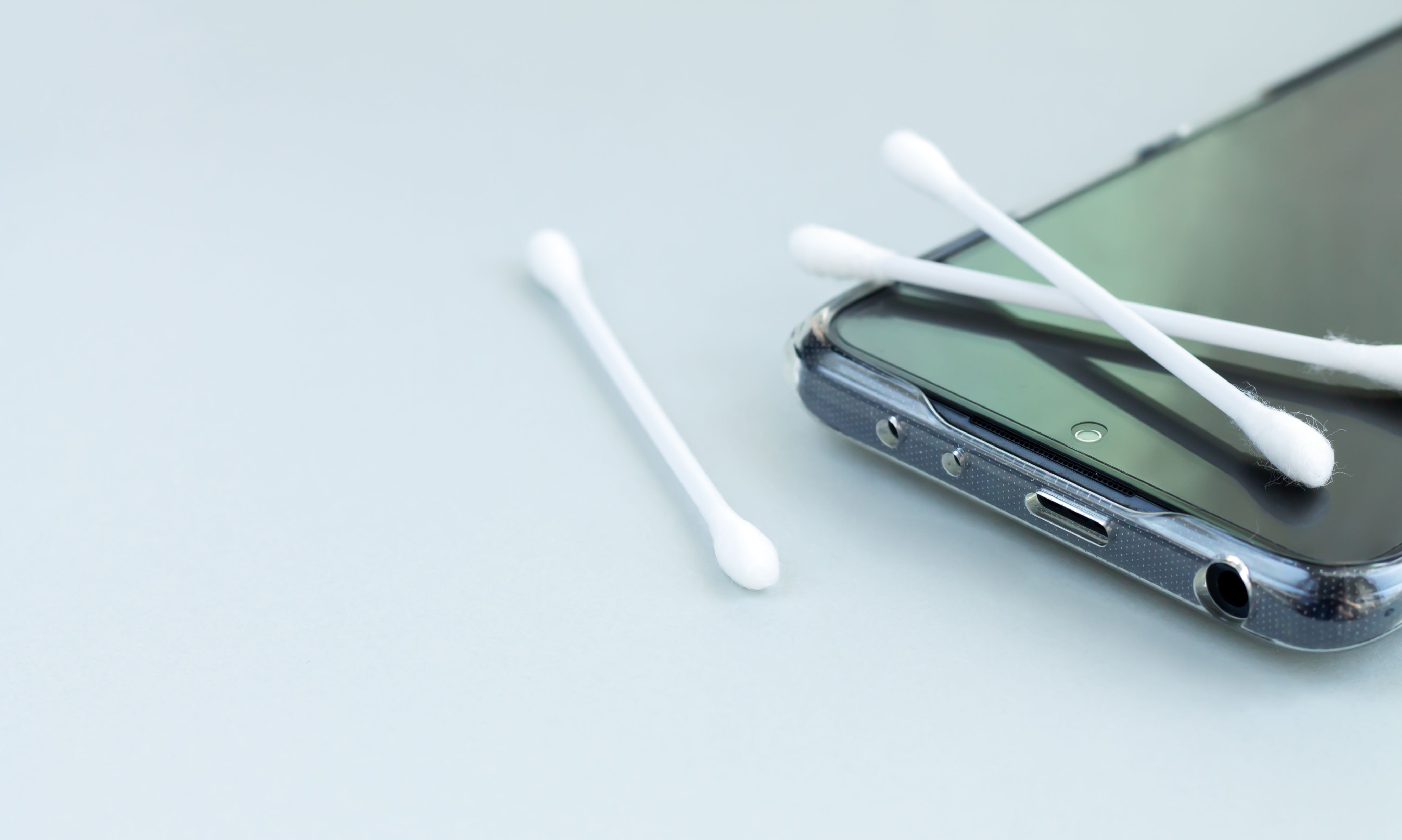 A mobile phone with cotton tips next to it