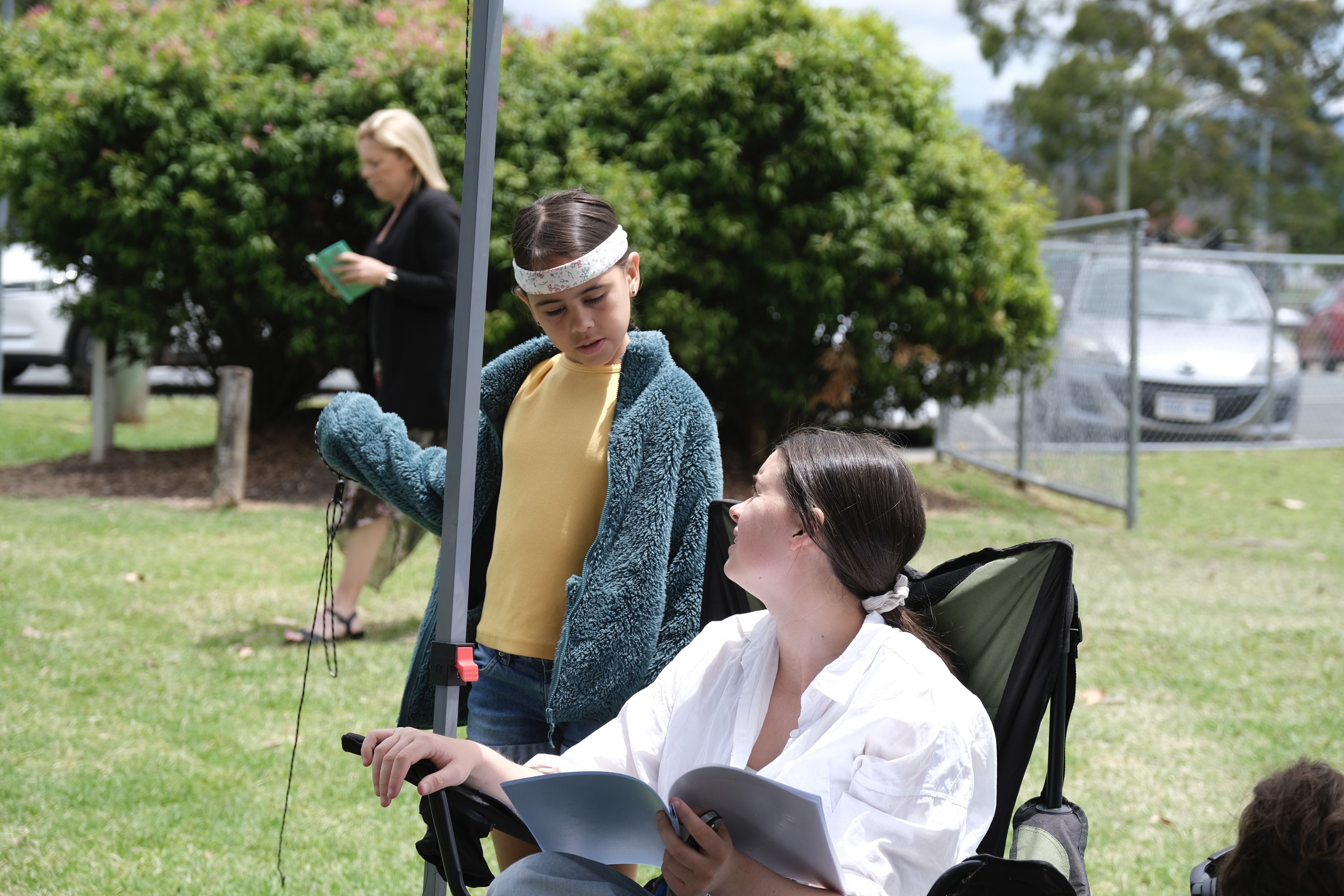 A child talks to a woman in a director's chair