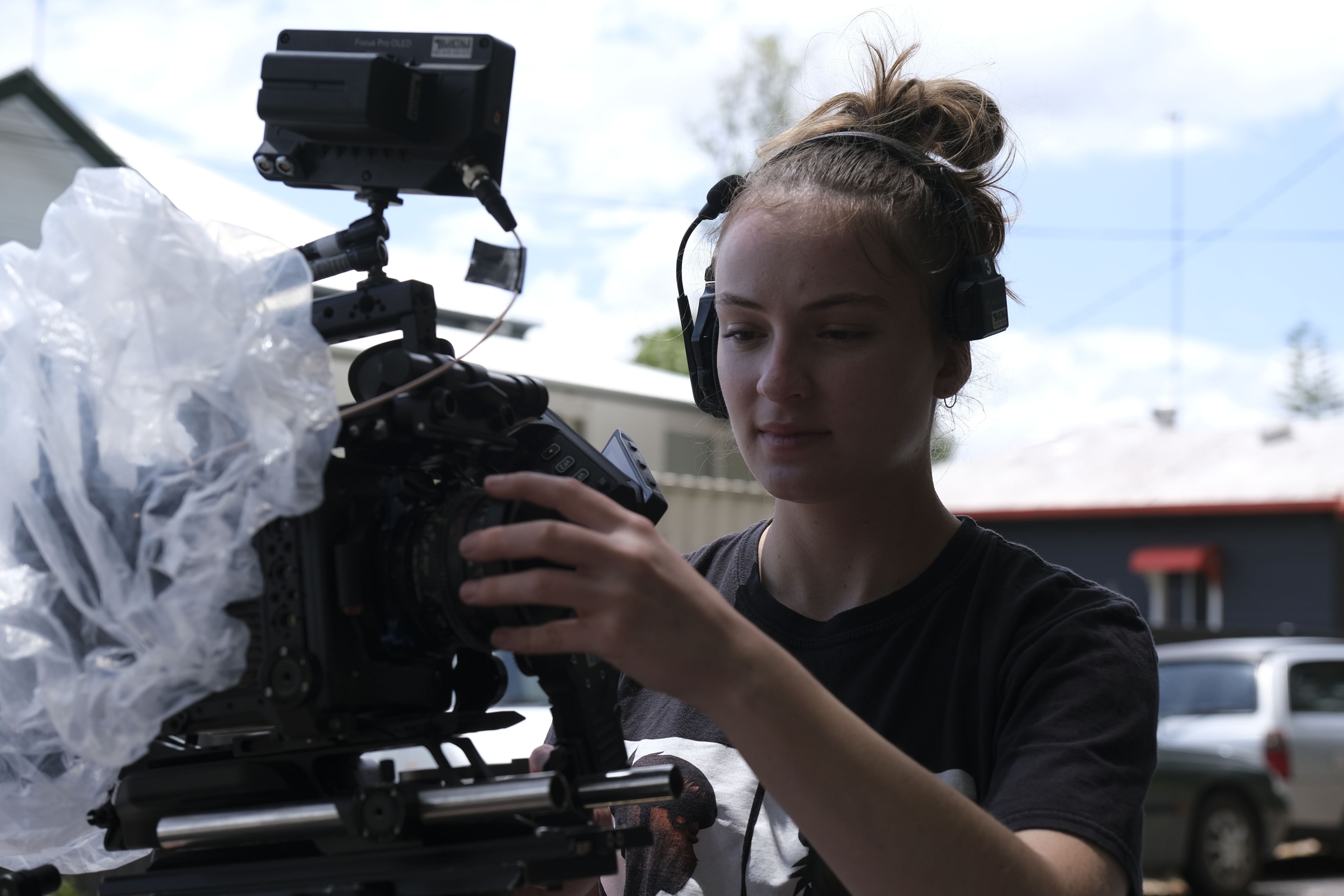 A woman wearing a headset holds a camera