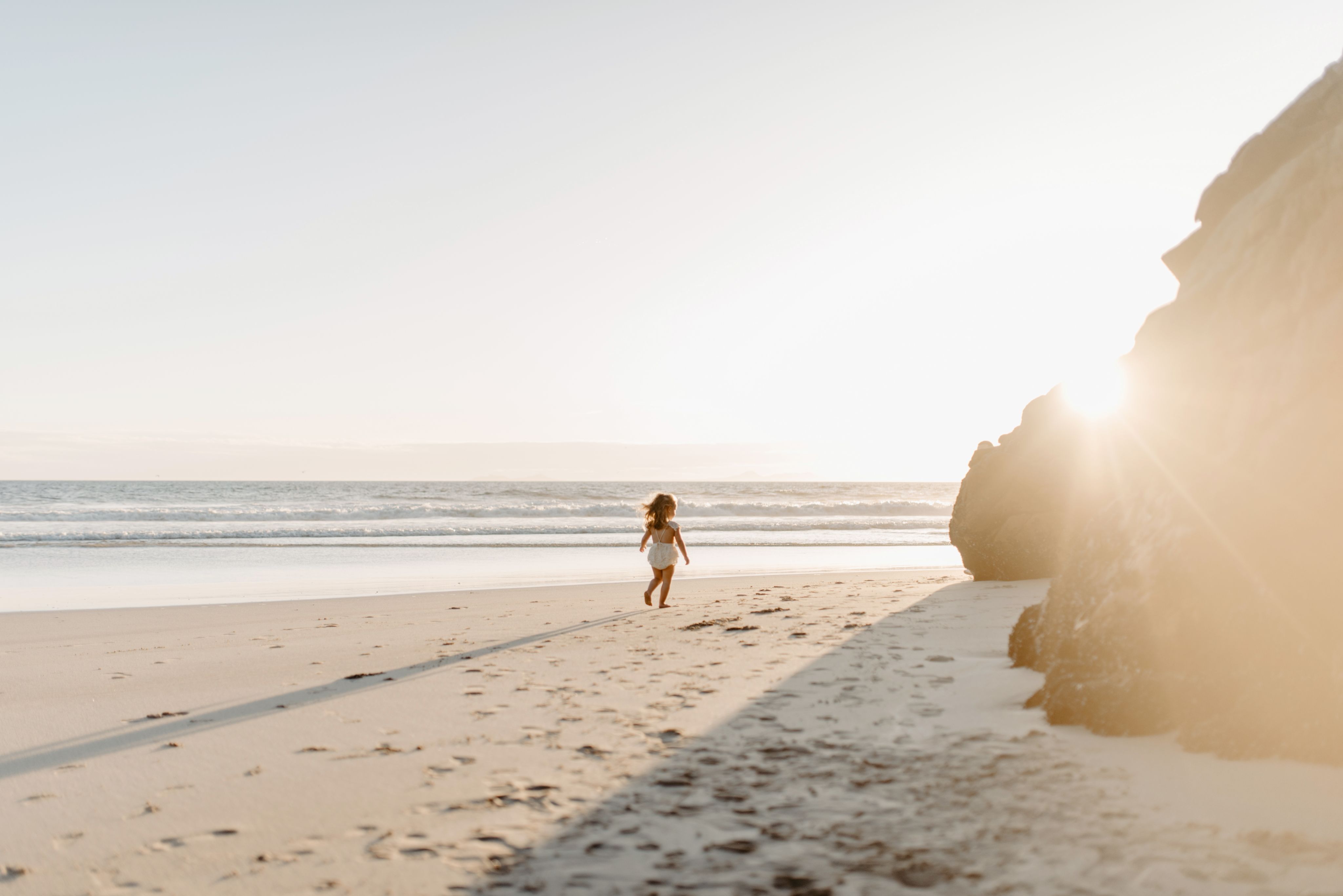 a person toddler on the beach at sunrise