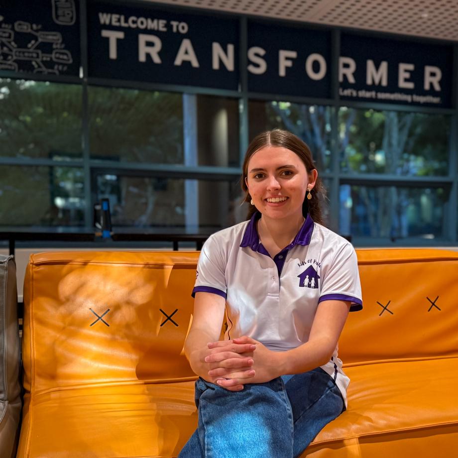 Ruby Allen sits on a couch in the Transformer space