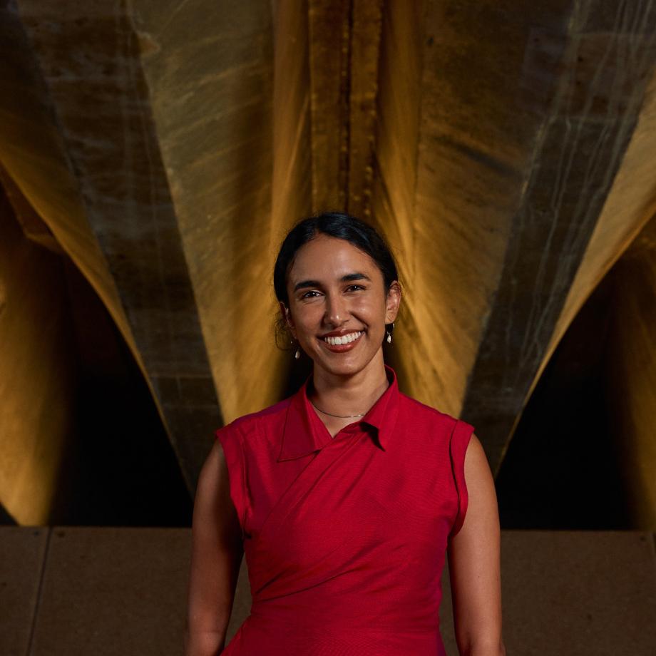 a woman smiling, wearing a red dress