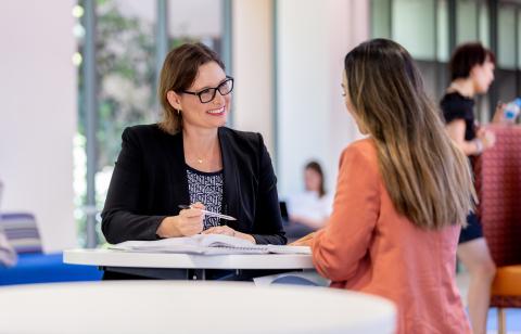 A student speaks with a teacher in the Bond University Faculty of Law building.