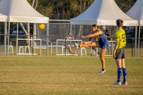 Bull Sharks QAFLW player kicking for goal