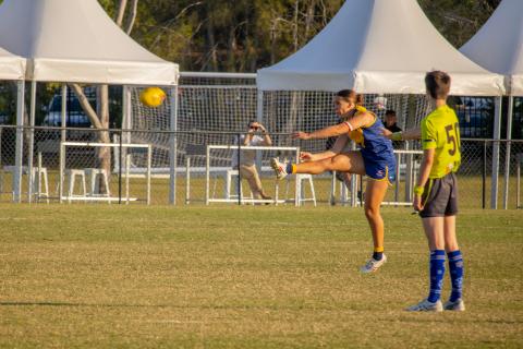 Bull Sharks QAFLW player kicking for goal 