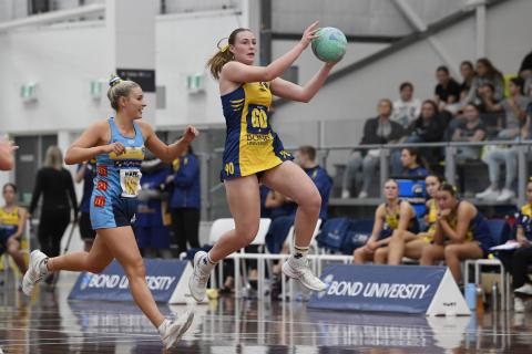 Bond University netball player jumping to catch the ball
