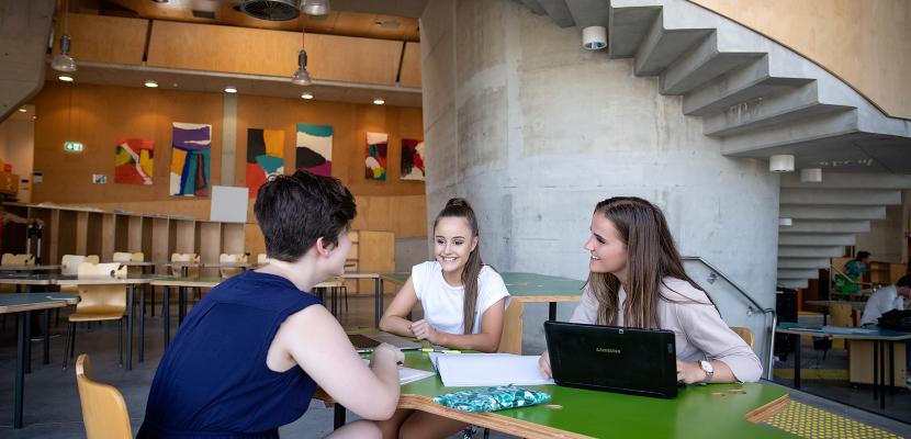 Three females sitting in the Abedian School of Architecture building.