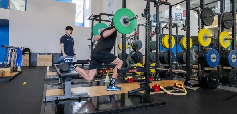 male performing a weighted lunged in the High Performance Training Centre
