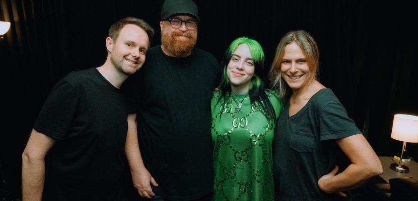 Alumnus Trevor Smith, smiling in a group which includes famous singer Billie Eilish
