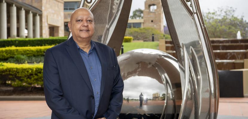 Sushil Sukhwani stands in front of the Bond Limitless sculpture