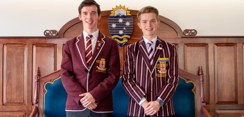 Two students from Prince Alfred College, Adelaide standing on Moot Court side by side with Bond emblem in background.