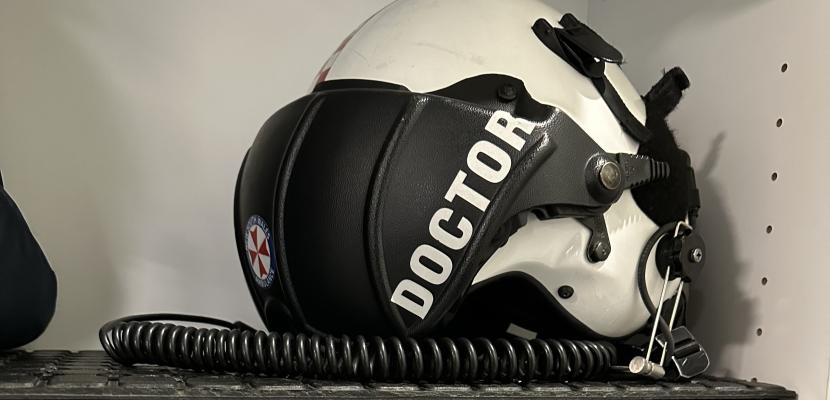 A helmet for flying with "Doctor" written on the side, pictured on a shelf. 