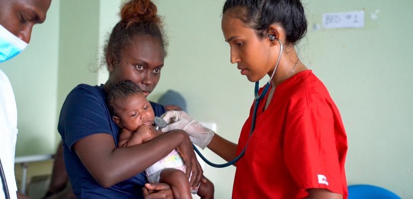 Bond Medicine student listening to the heartbeat of a baby at a hospital in the Solomon Islands during their Capstone Placement.