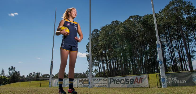 Women's AFL player standing for a photo on a sunny day. 