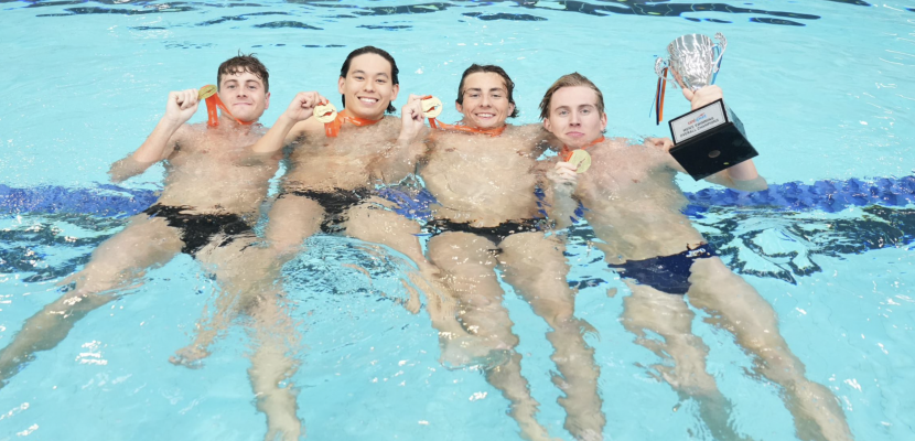Four male members of the Bond University Swimming team posing with their medallions in the pool