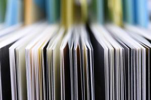 Black, yellow and red paper folders stacked closely together. 