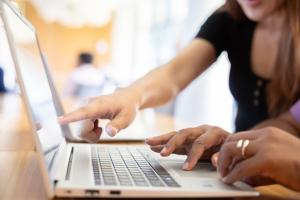 A person pointing at a laptop screen